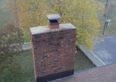 Newly capped chimney with trees in the background.