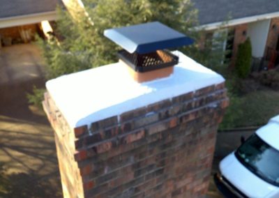 Repaired chimney crown with truck and homes in the background.