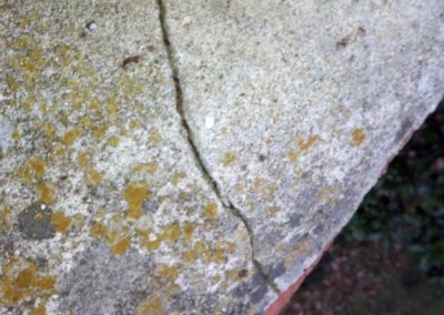 Cracked chimney crown next to flue.