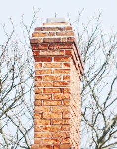 red brick chimney against trees
