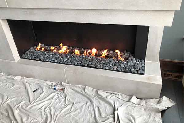Update your fireplace with a remodel - White surround with gas flames and rocks.