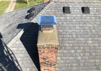 Stainless steel chimney cap with fans on the roof.