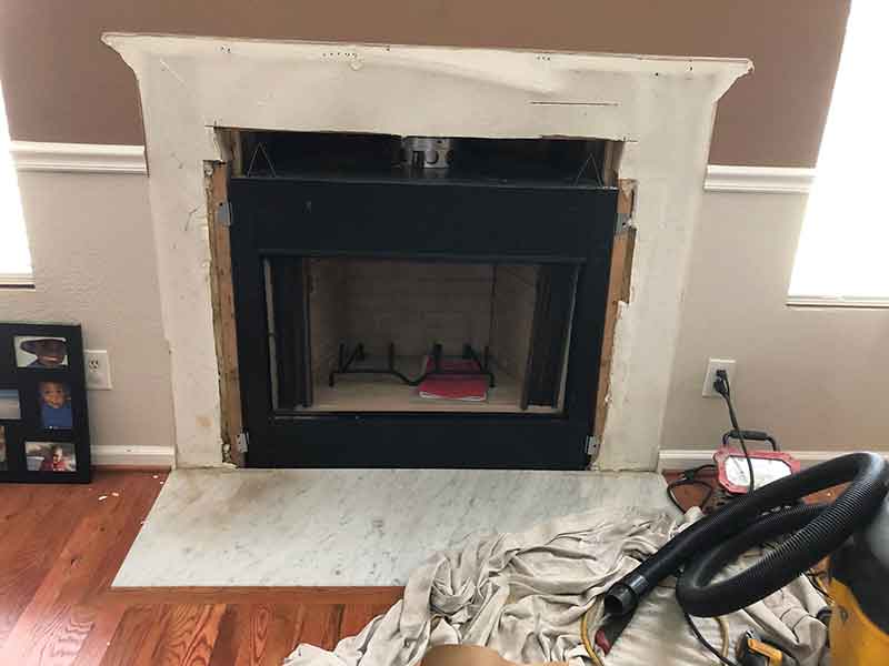 Fireplace tear out with vacuum to the right.