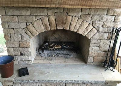 Keystone rock fireplace with tools to the right and bucket on the left.