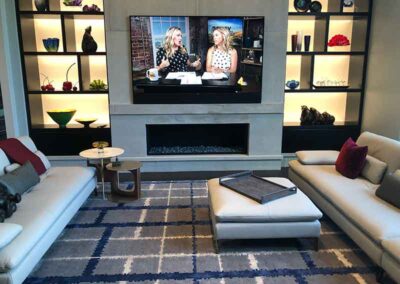 Modern fireplace with tv on top shelves on each side and two couches.