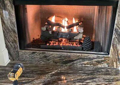 Gas Log insert with beautiful granite surround. Tool in the left hand corner.