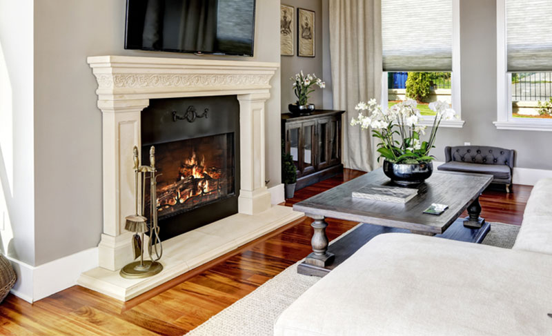 Living area with a white fireplace, table with flowers on it, and white couch