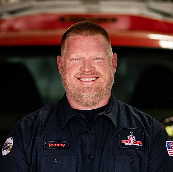 Original photo of owner Tommy Nelms - Sweeps and Ladders Owner Tommy Nelms in logo shirt. He has a beard.