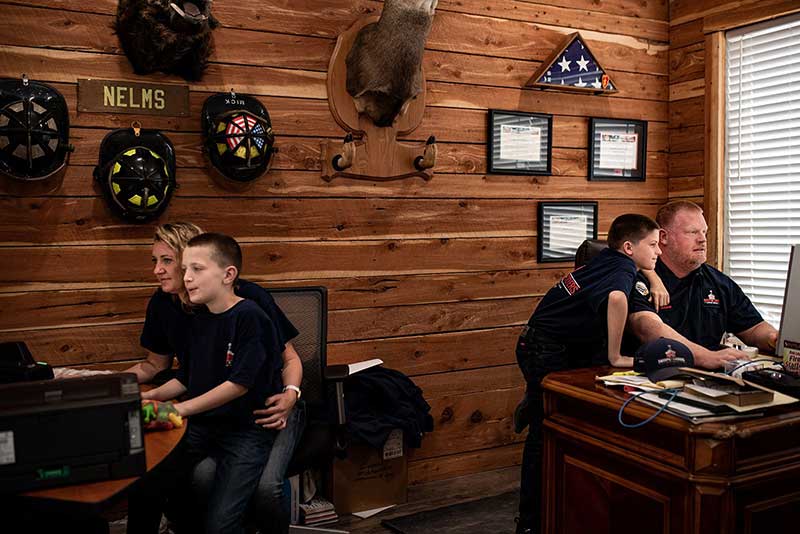 Tommy and Beka Nelms and their sons sitting at office desks.